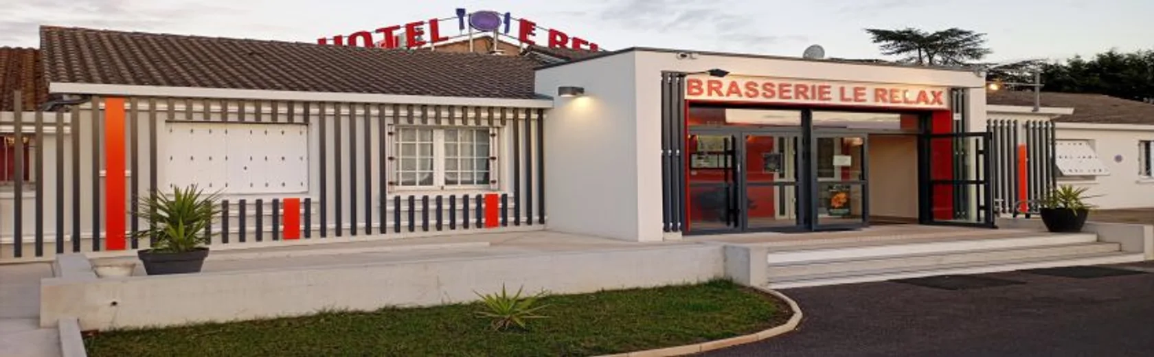 Façade de l'hôtel et de la Brasserie Le Relax au crépuscule